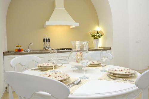 a dining room with a white table and white chairs at Dimora storica Santasofia a Martano in Martano