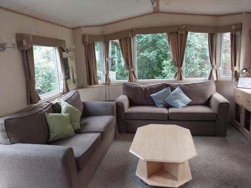 a living room with two couches and a table at A Hillside Retreat - with garden in Hastings