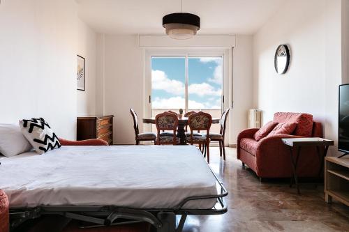 sala de estar con cama, sillas y ventana en DeHomes - Papa Giovanni XXIII en Buccinasco