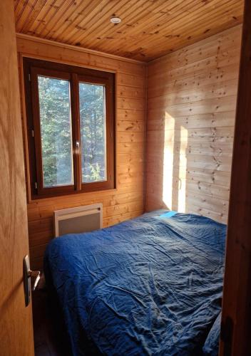ein Schlafzimmer mit einem Bett in einer Holzhütte in der Unterkunft Chalet du Mont Ventoux - Rendez-vous en Provence in Bédoin