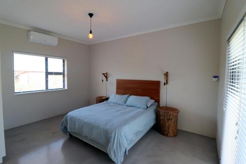 a bedroom with a bed and a window at Karen Close 3219 in Struisbaai