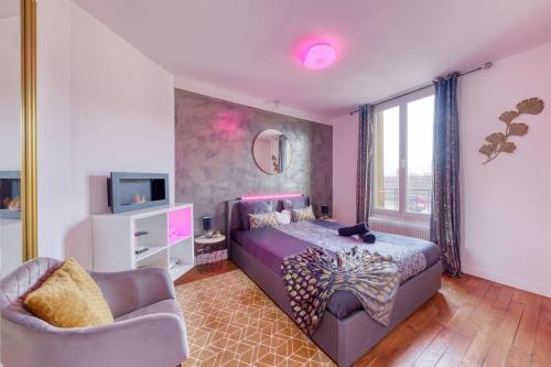 a bedroom with a bed and a couch and a tv at Le Cocon - Cinéma in Gentilly