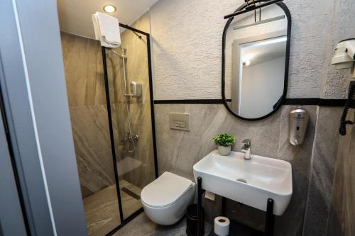 a bathroom with a sink and a toilet and a mirror at Arkem Hotel 2 in Istanbul