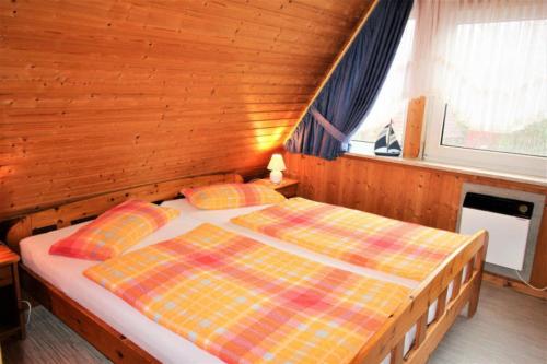 ein Schlafzimmer mit einem Bett in einem Holzzimmer in der Unterkunft Knechtsand in Dorum Neufeld