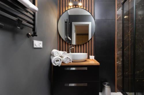 a bathroom with a sink and a mirror at Apartament Pomorska in Gdańsk