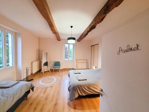 a bedroom with two beds in a room with wooden floors at Gîte campagne famille 15 pers Piscine chauffée Jeux enfants Pétanque in Saint-Sauvy