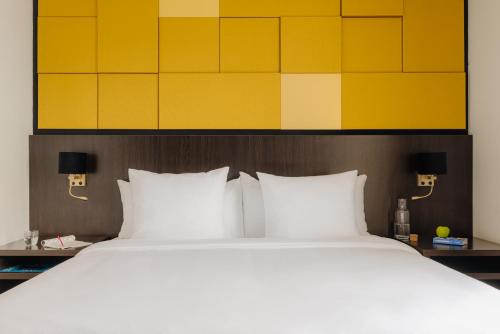 a large bed with white pillows in a hotel room at Leonardo Oranje Hotel Leeuwarden in Leeuwarden
