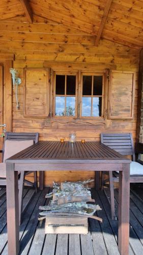une cabane en bois avec une table et des chaises en bois dans l'établissement wooden cabin in nature, à Troche