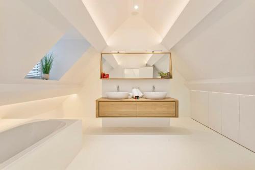 een badkamer met 2 wastafels en een spiegel bij Luxurious villa with sauna in the countryside near Knokke in Knokke-Heist