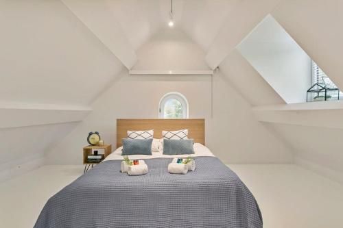een slaapkamer met een groot bed met 2 kussens bij Luxurious villa with sauna in the countryside near Knokke in Knokke-Heist