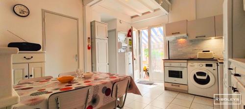 une cuisine avec une table recouverte d'une nappe dans l'établissement Maison de vacances climatisée à 600m de la plage, à Vias