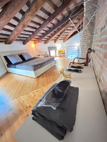 Chiesetta abside ex seminario - ApartamentRovigo في روفيغو: غرفة نوم كبيرة مع سرير وجدار من الطوب