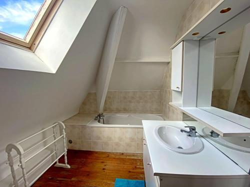 a bathroom with a sink and a bath tub at RÉF 407 - LARMOR PLAGE Maison de famille pleine vue mer in Larmor-Plage