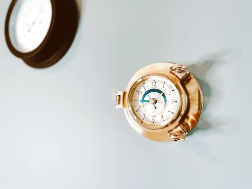 a gold watch sitting on a table next to a clock at 6 Knightshaven Holiday Village - Valentia Island in Knights Town