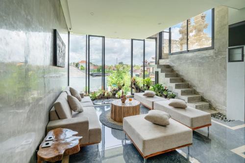 een woonkamer met banken en een trap met ramen bij Casa Jenah Three Bedroom Villa in Kesiman