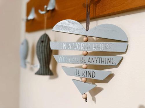a wooden heart with in a world where you can be anything be kind at 6 Knightshaven Holiday Village - Valentia Island in Knights Town