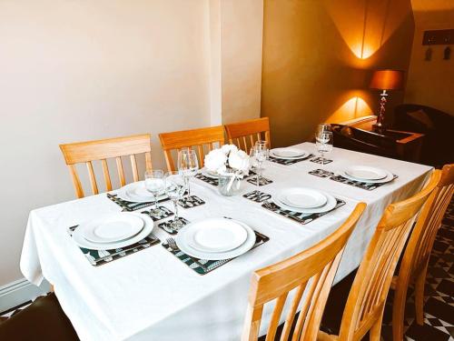 a table with white plates and glasses on it at 6 Knightshaven Holiday Village - Valentia Island in Knights Town