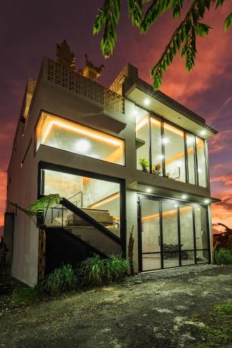 a house with large windows and a sunset at Casa Jenah Three Bedroom Villa in Kesiman