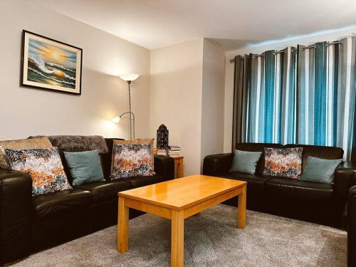 a living room with two couches and a coffee table at 6 Knightshaven Holiday Village - Valentia Island in Knights Town