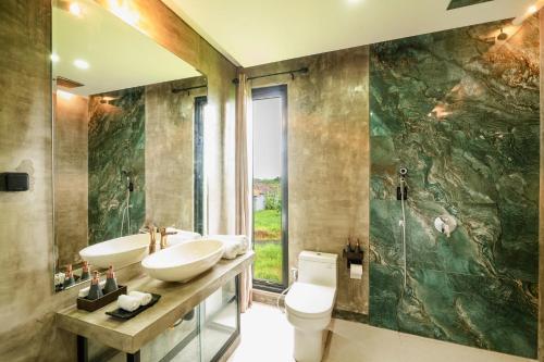 een badkamer met 2 wastafels en een grote spiegel bij Casa Jenah Three Bedroom Villa in Kesiman