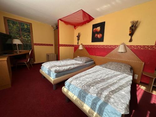 een hotelkamer met 2 bedden en een bureau bij Gasthaus zur Schwarzen Olive Zimmer 12 in Erlangen