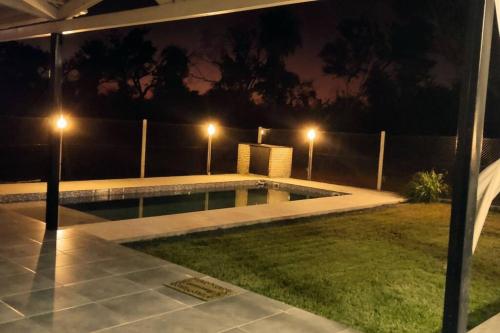 a swimming pool in a yard at night at Casa Quincho con Piscina in Luque