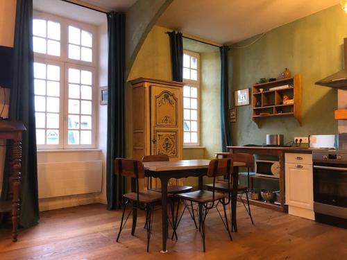 une cuisine avec une table et des chaises dans une pièce dans l'établissement Appartement pour 2 personnes à 50 mètres du port, à Paimpol