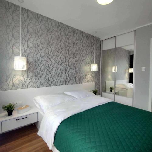 sypialnia z dużym łóżkiem i lustrem w obiekcie Zielony Makusz w Wałbrzychu