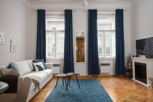 a living room with blue curtains and a couch at AIRSTAY PRAGUE apartment Vinohrady in Prague