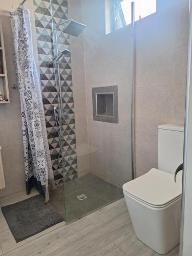 a bathroom with a shower with a toilet and a glass door at Enjoy Paradise Newave Holiday - Appartment No 8 in Flic-en-Flac