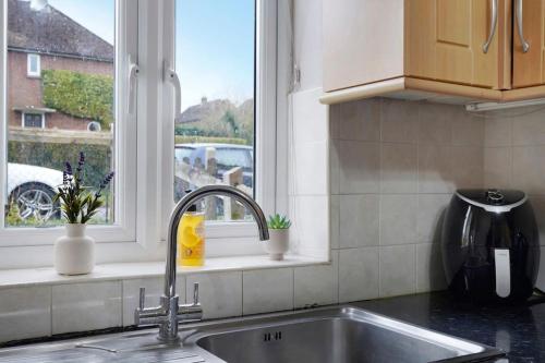 um lavatório de cozinha com uma janela numa cozinha em Beautiful 2 Bedroom house, Wendover Free Parking em Wendover