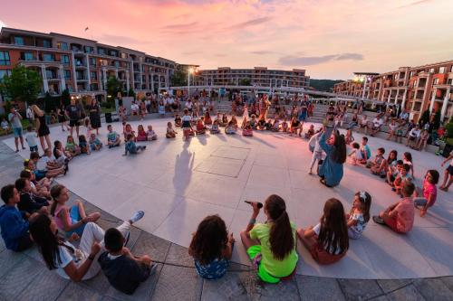 un grupo de personas sentadas en el suelo viendo un concierto en Premier Fort Beach Hotel, en Sveti Vlas