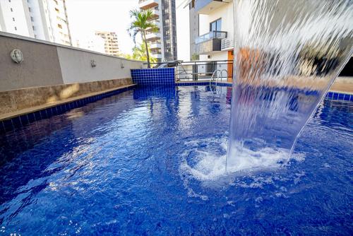 una fuente en medio de una piscina en Sun Square Suítes Hotel By Lual, en Goiânia