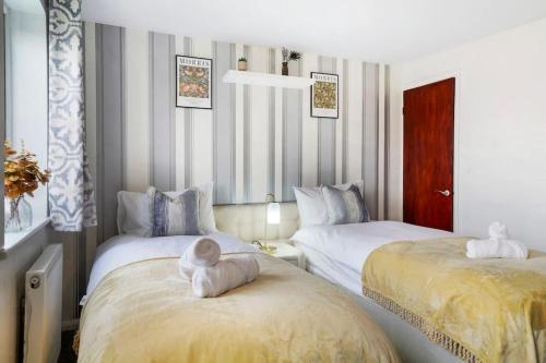 um quarto com duas camas com um bicho de peluche sentado em cima delas em Beautiful 2 Bedroom house, Wendover Free Parking em Wendover