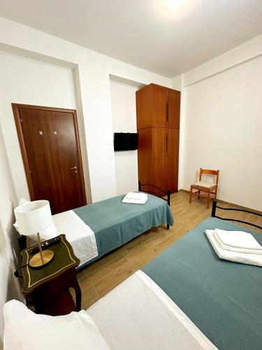 a hotel room with two beds and a chair at La Casa di Garibaldi - Vista per le Montagne in San Demetrio neʼ Vestini