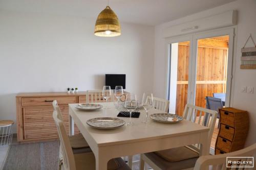 - une salle à manger avec une table et des verres à vin dans l'établissement Marina Lodge - Villa climatisée avec piscine, à Vias