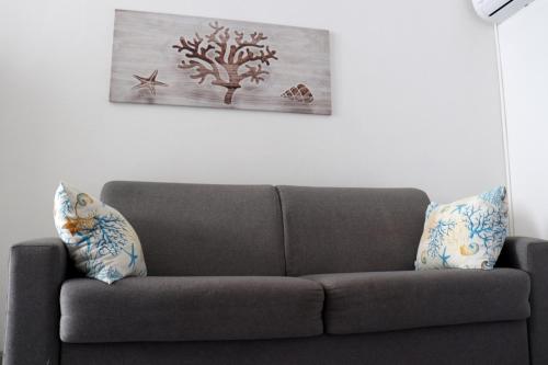 a couch in a living room with a painting on the wall at Appartamento La Pelosa in Stintino