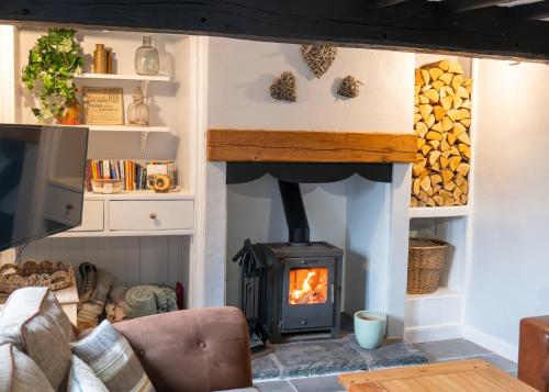 a fireplace in a living room with a stove at Cottage On The Brook in Keswick