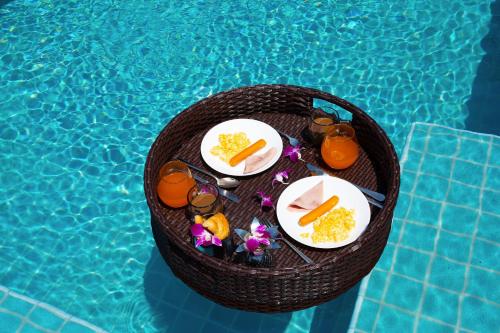 una mesa con comida y bebida en una cesta junto a la piscina en Villas In Pattaya, en Jomtien Beach