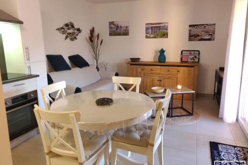 Il comprend une cuisine et un salon avec une table et des chaises. dans l'établissement Villa T3 à 400m de la plage avec piscine, à Vias