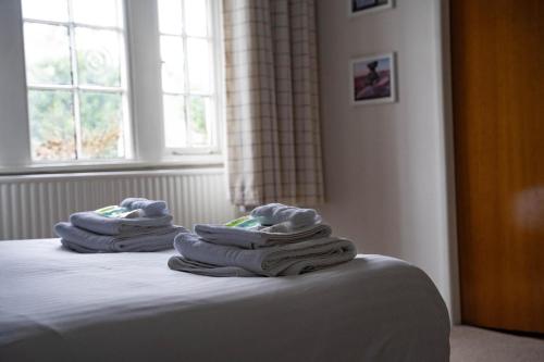 two stacks of towels sitting on top of a bed at The George Inn at Tideswell in Tideswell