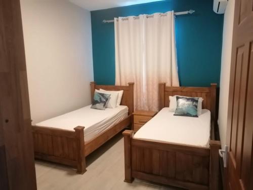 two beds in a room with blue walls at Enjoy Paradise Newave Holiday - Appartment No 8 in Flic-en-Flac