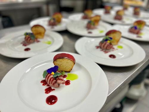 a row of white plates of food on a table at Penzión a Reštaurácia Harmónia Ostratice in Malé Ostratice