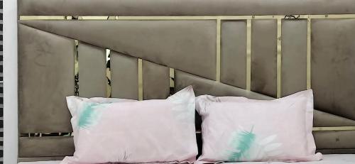 two white pillows sitting on a bed with a headboard at PRIYAMVADA FAMILY HOMESTAY in Vrindāvan