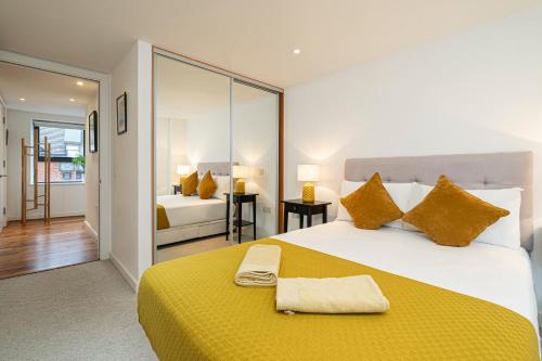 a bedroom with a large bed with a yellow blanket at Stay Fleet Street in London