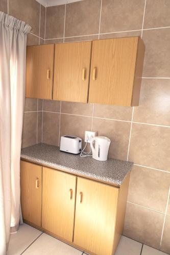 a kitchen with wooden cabinets and a counter top at Klinkies in Potchefstroom