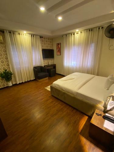 een slaapkamer met een bed, een bureau en een stoel bij KAFT2 HOTELS in Ijebu Ode