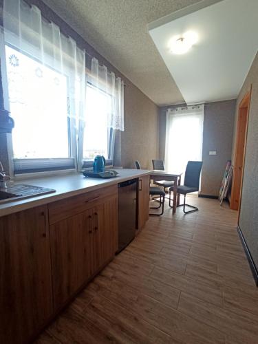 una cocina con armarios de madera y una mesa con sillas. en Pokoje Jadwiga Konkel, en Jastarnia