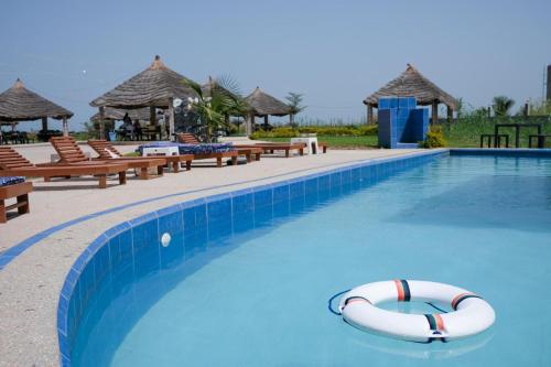 una piscina en un complejo con 2 ayudas para nadar en Lovely 13-Bed Complex on Cape Point Beach Bakau - Bojang River Lodge, en Bakau