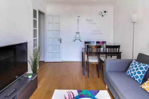 un salon avec un canapé et une table dans l'établissement Appartement Garros - Welkeys, à Boulogne-Billancourt